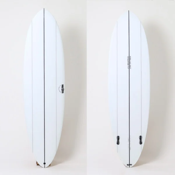 110101jjjbbara_1 - SHOP NEWS | ムラサキスポーツオンラインストア 通販 Two white surfboards standing upright against a pale background, showing central stringers and at least one fin near the tail of each board.