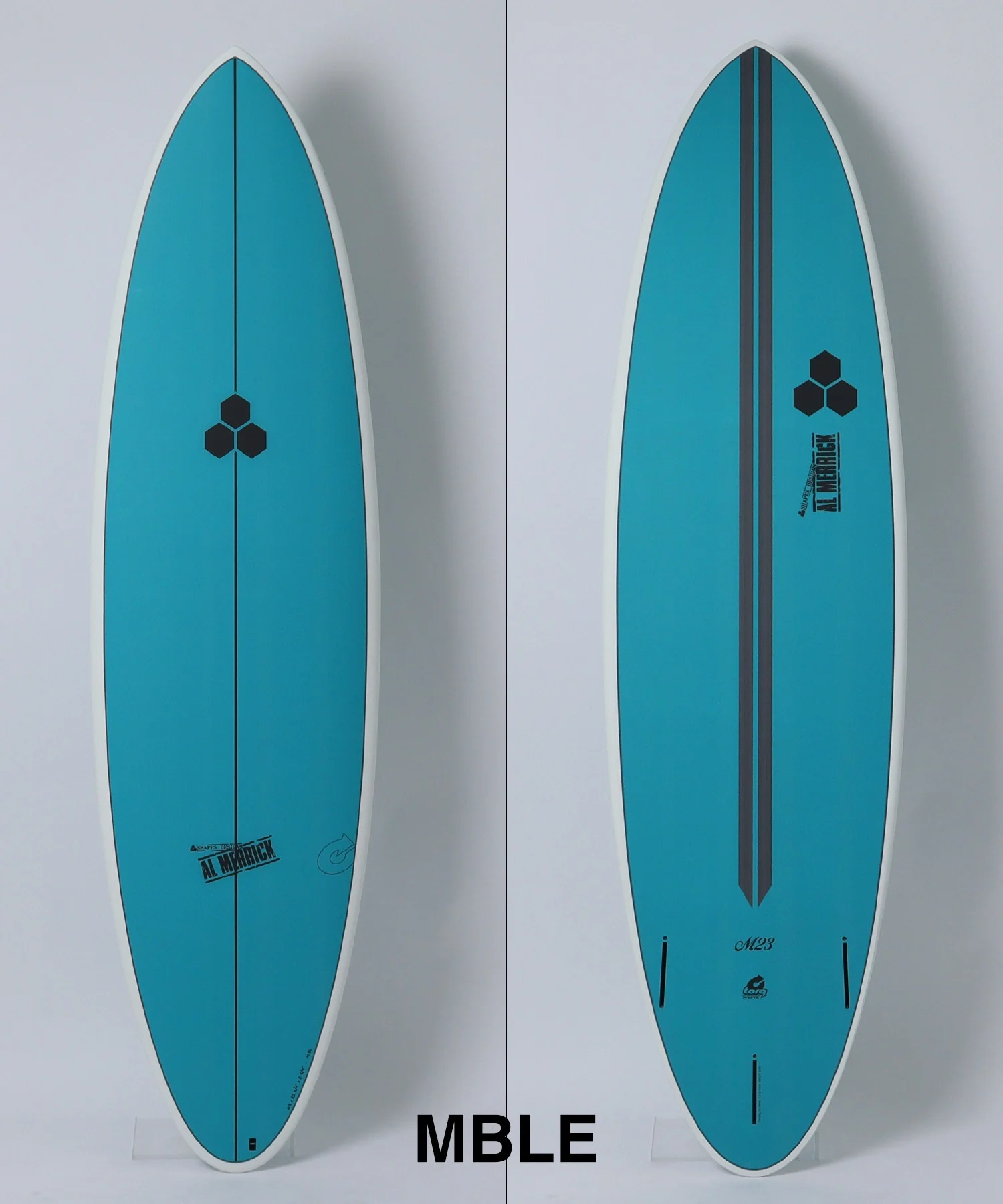 image - SHOP NEWS | ムラサキスポーツオンラインストア 通販 Two teal surfboards shown side-by-side against a light background, front view on the left with a vertical line and hexagon logo in the center; back view on the right with a stripe and logo.